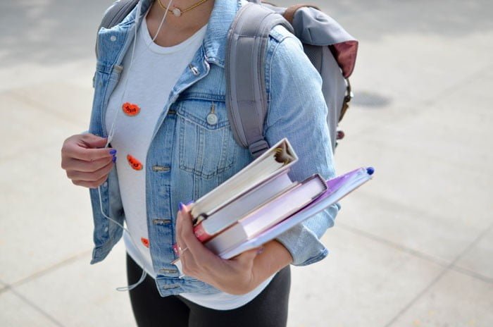 student holding books for university