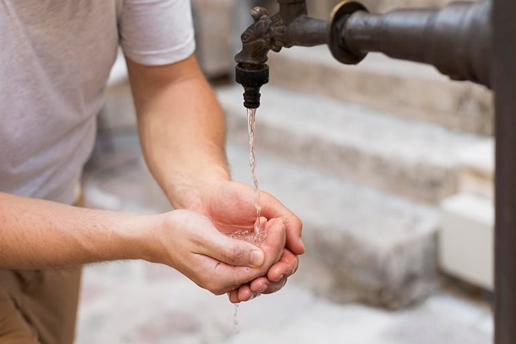 Picture shows human drinking water from tap